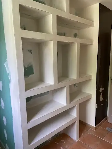 Bibliothèque en plaques de plâtre enduites, niches et étagères de tailles différentes